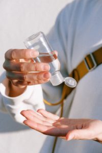 An office worker using hand sanitiser to improve office hygiene